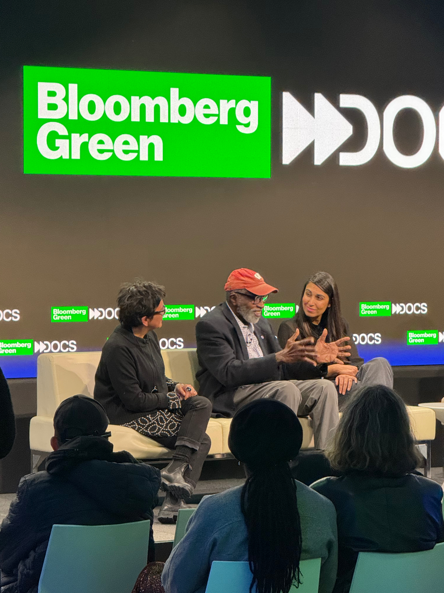 Moderator and two filmmakers in mid-conversation on the Bloomberg Green Docs stage.